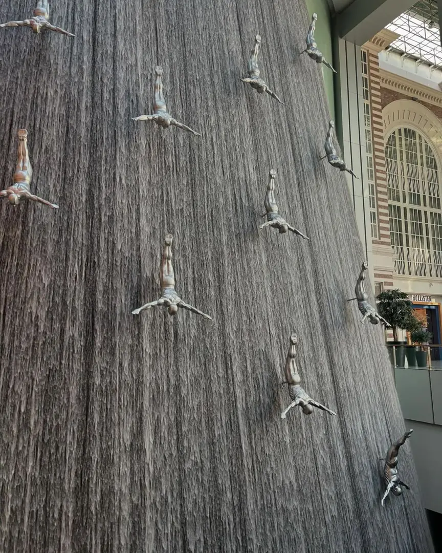 Diver sculptures suspended in a falling-water installation, Dubai. Photograph by Arav Jain.