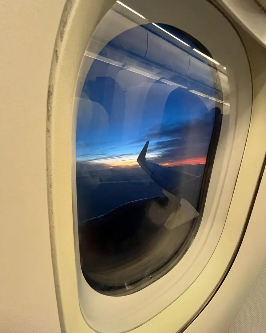 Sunset over the cloud line seen through an aircraft window. Photograph by Arav Jain.