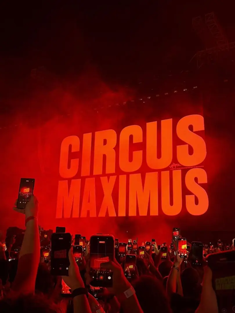 A concert crowd lit red, phones raised, Circus Maximus tour. Photograph by Arav Jain.