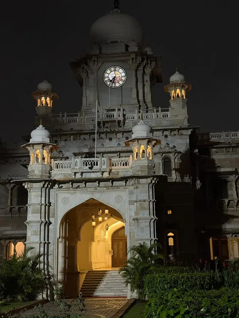 A floodlit colonial-era clock tower gateway at night. Photograph by Arav Jain.